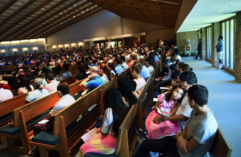 Rocio Cruz (facing camera), 7, sits with her father, Jose Carlos Cruz, during a Spanish Mass at Good Shepherd Catholic Church last month in Alexandria, Va. Hispanics account for 34 percent of American Catholics. Matt McClain/The Washington Post via Getty Images hide caption